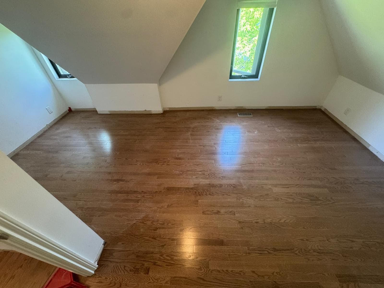 Rich hardwood flooring in a bright finished room